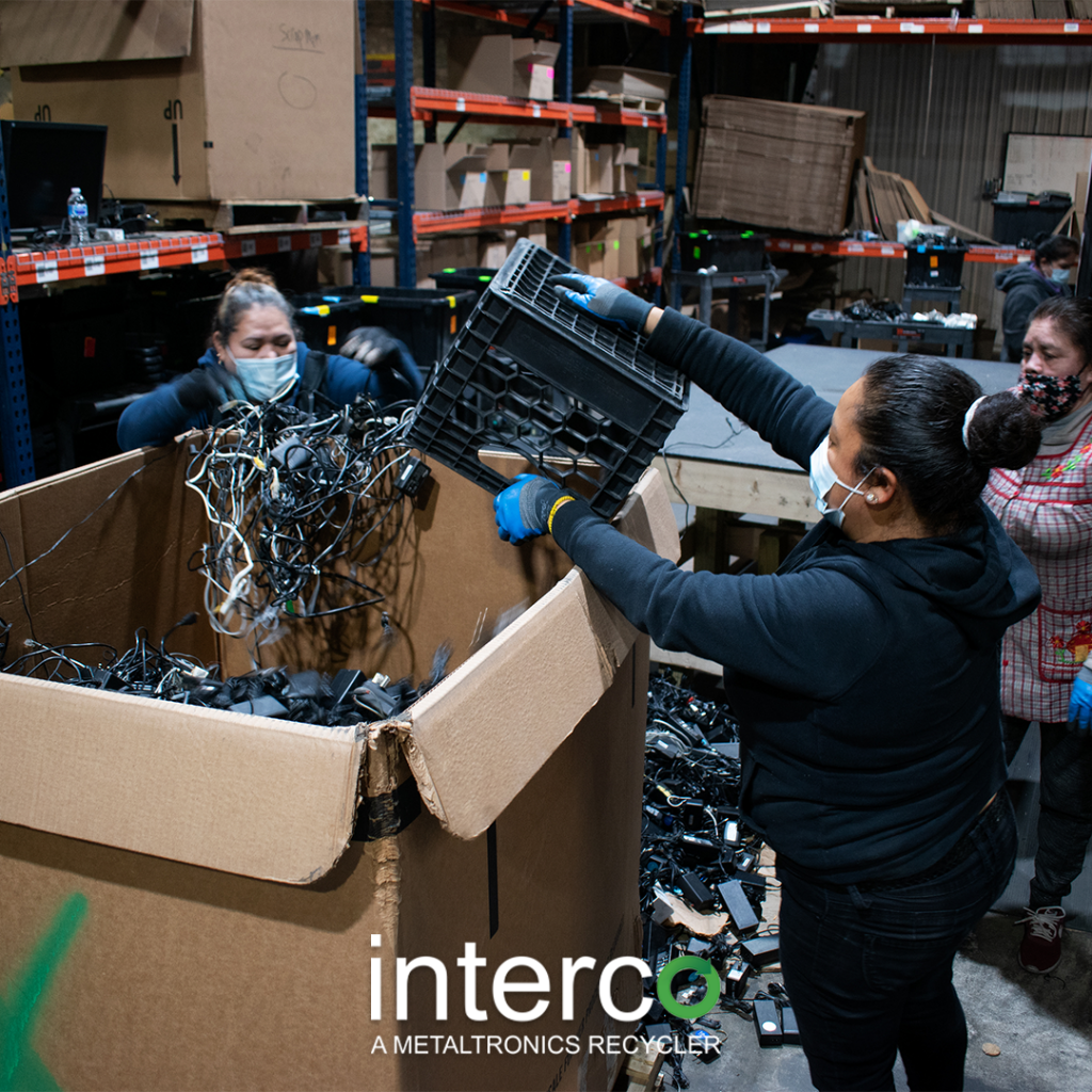 Interco employees inspecting a box of  recycled electronics